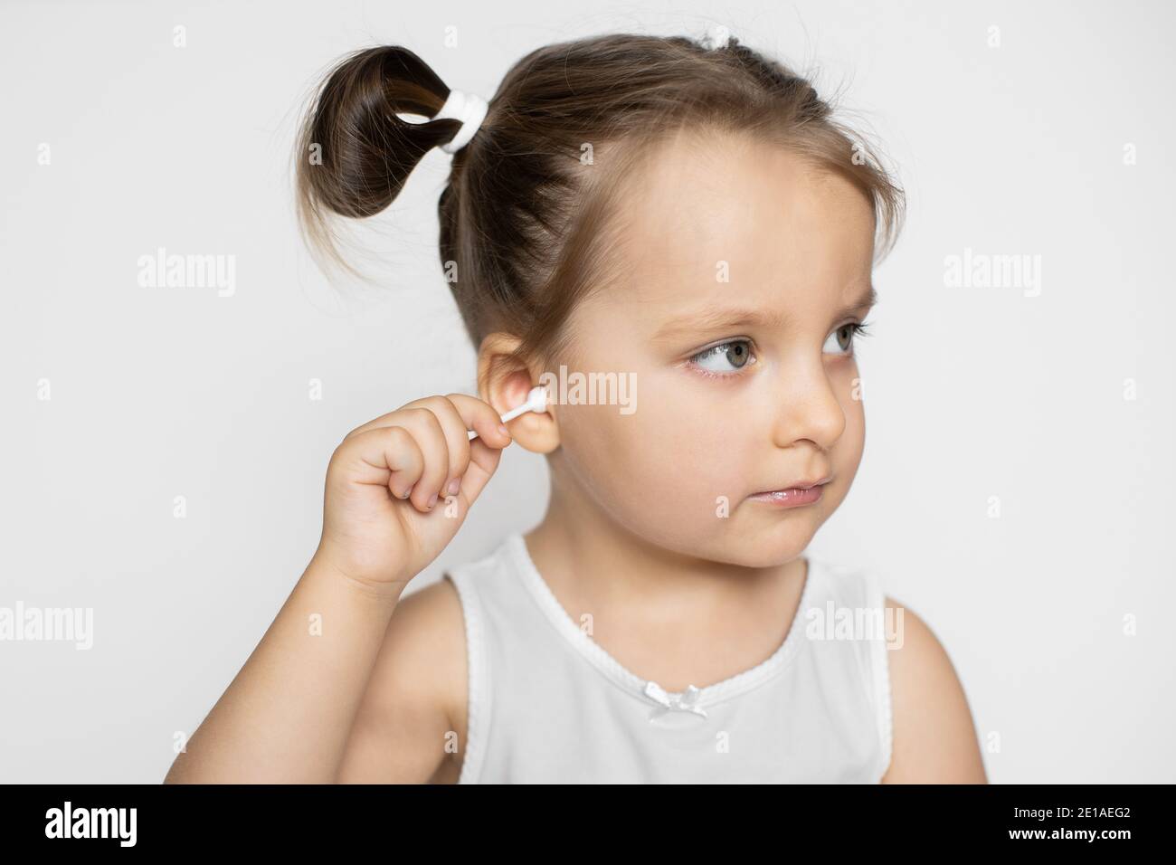 Ear cleaning, skincare concept. Little attractive kid girl, looking
