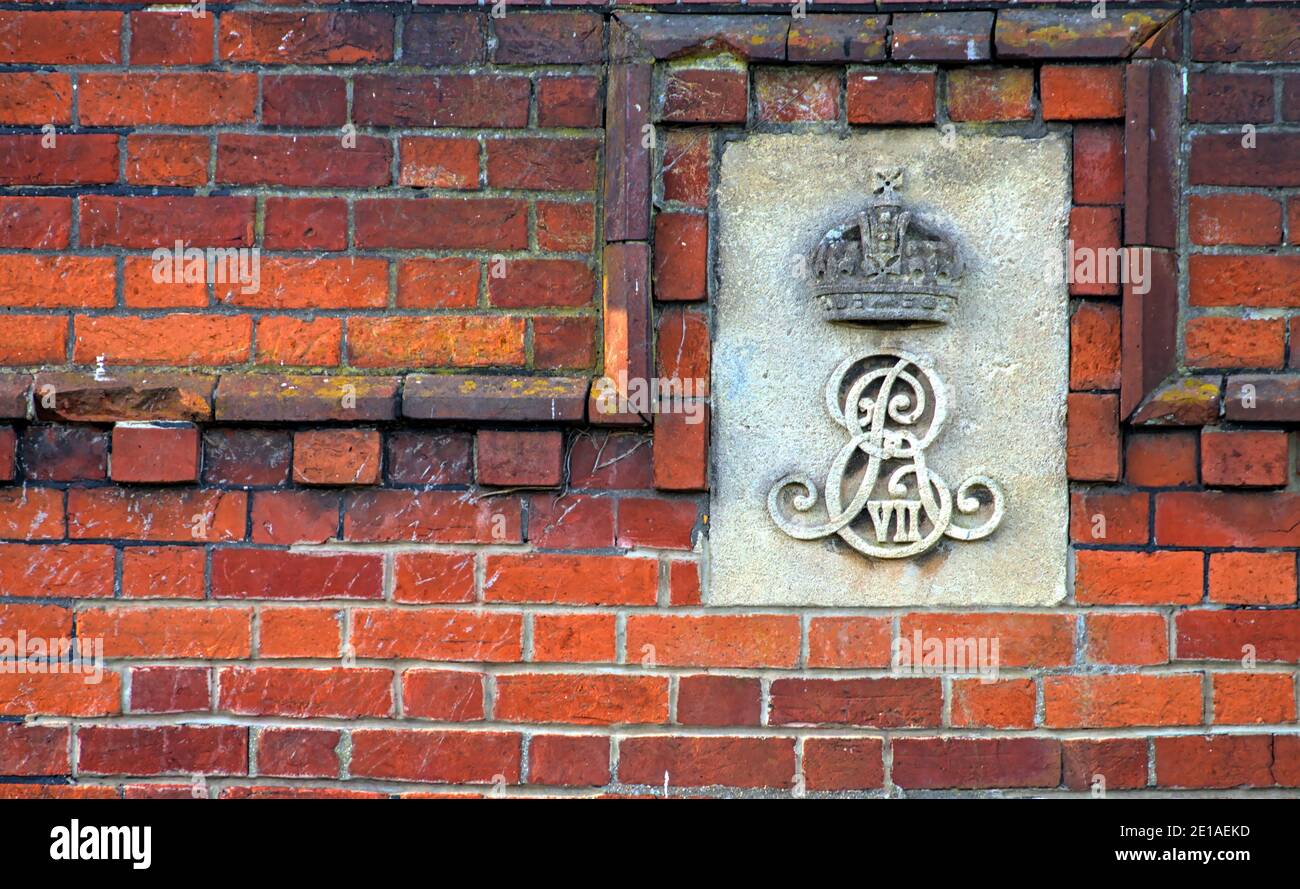 King Edward VII Monogram Carved Into A Stone Plaque Fixed To The Side Of An Old Red Brick Wall On the Side Of Holmsley Toll House, New Forest UK Stock Photo