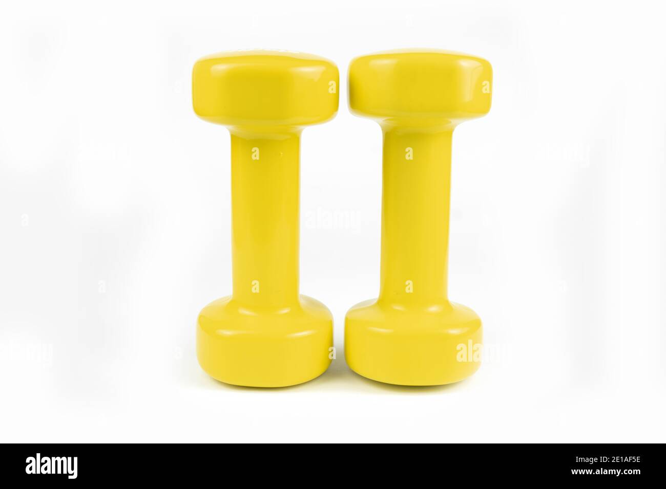 Two yellow dumbbells on white background Stock Photo