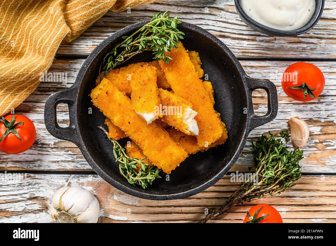 Oven baked crumbed fish sticks made from white fish. White background