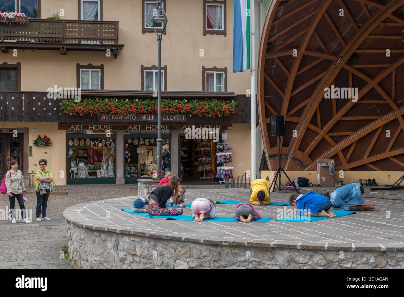 A group of kids make yoga in the city center from the town Cortina. Stock Photo