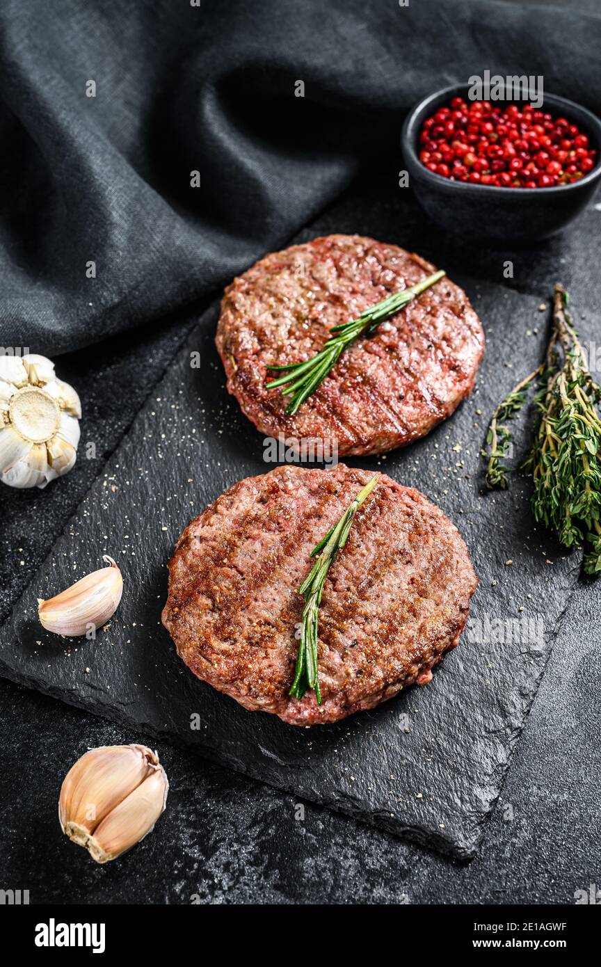 Grilled ground beef patties. BBQ meat. Black background. Top view Stock