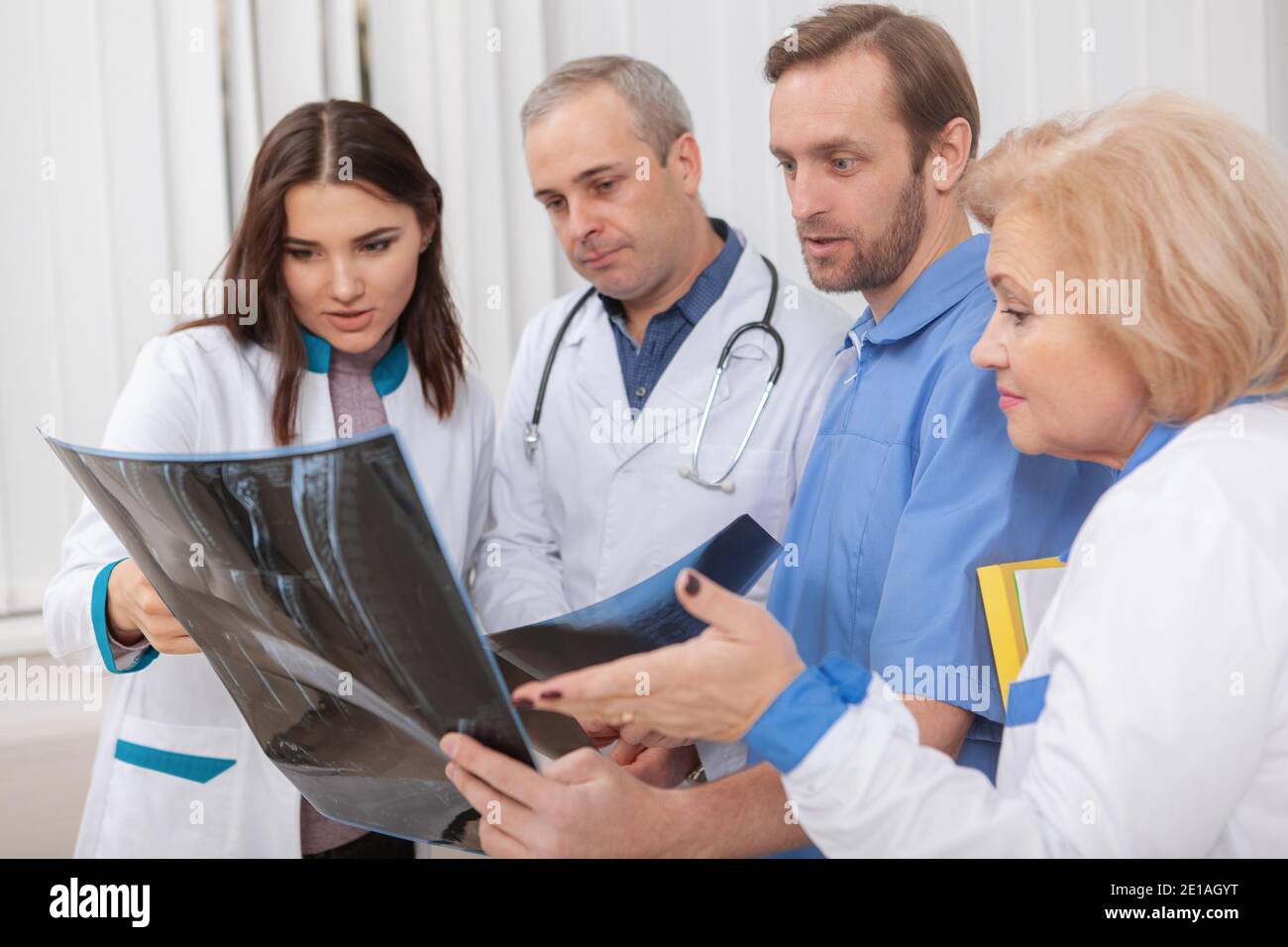 Group of medical workers examining MRI scan of a patient together ...