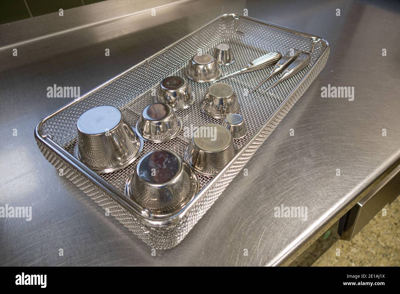 various surgical instruments lie in sieves on a work surface Stock