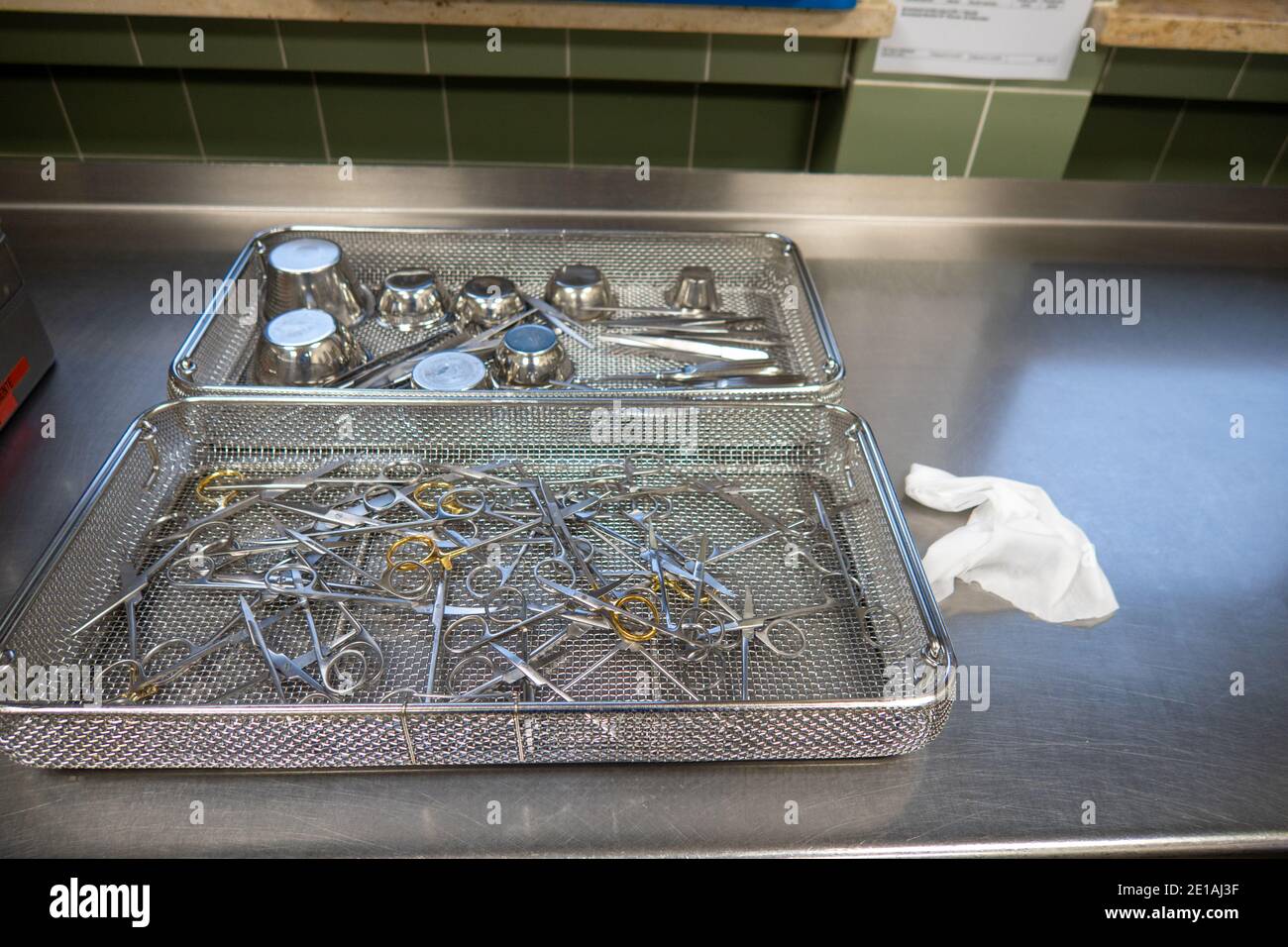 various surgical instruments lie in sieves on a work surface Stock