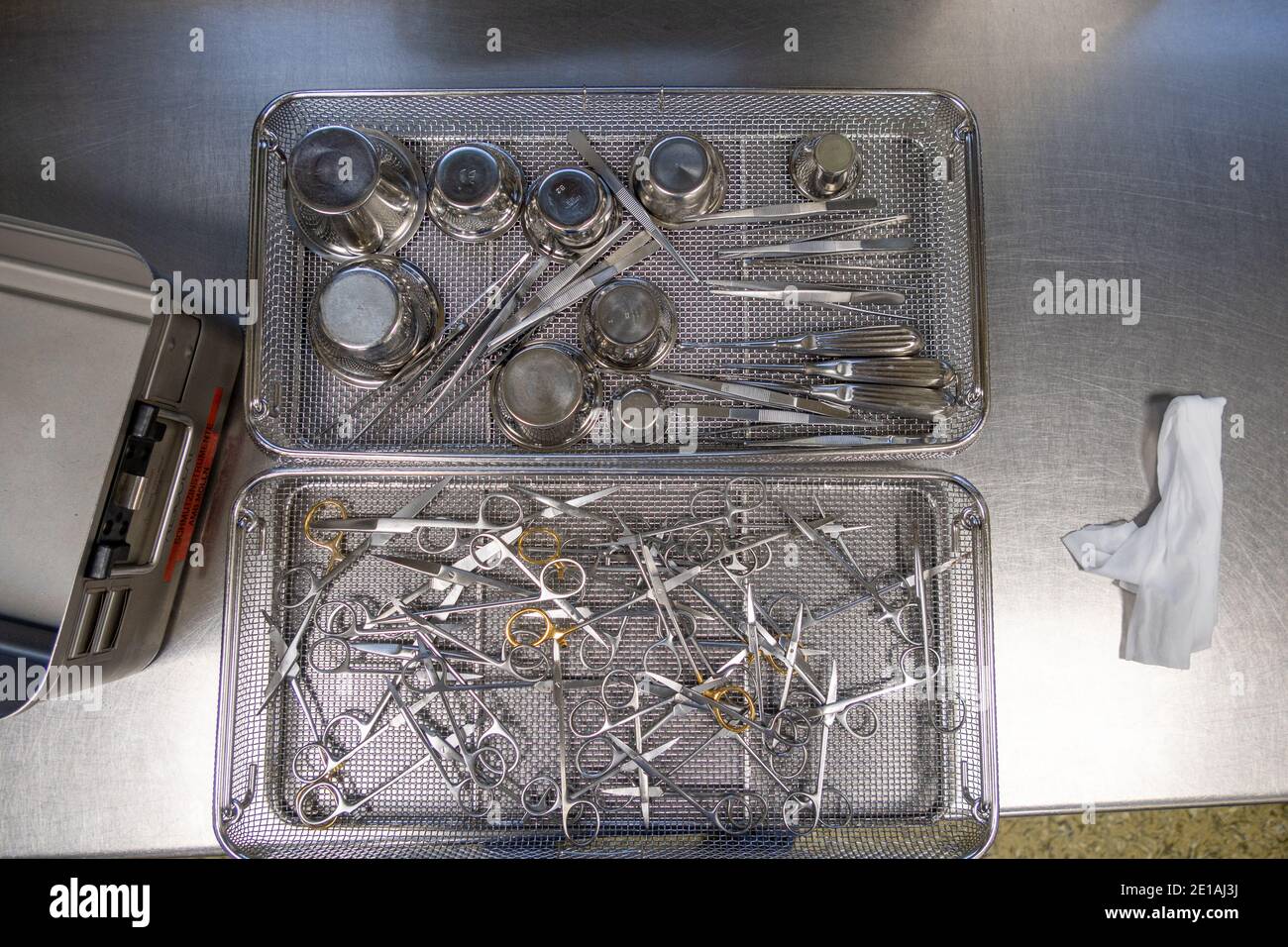 various surgical instruments lie in sieves on a work surface Stock