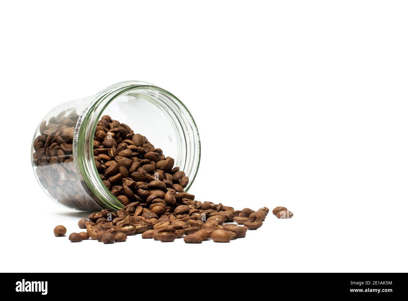 Transparent jar with coffee beans spilled on the table Stock Photo Alamy