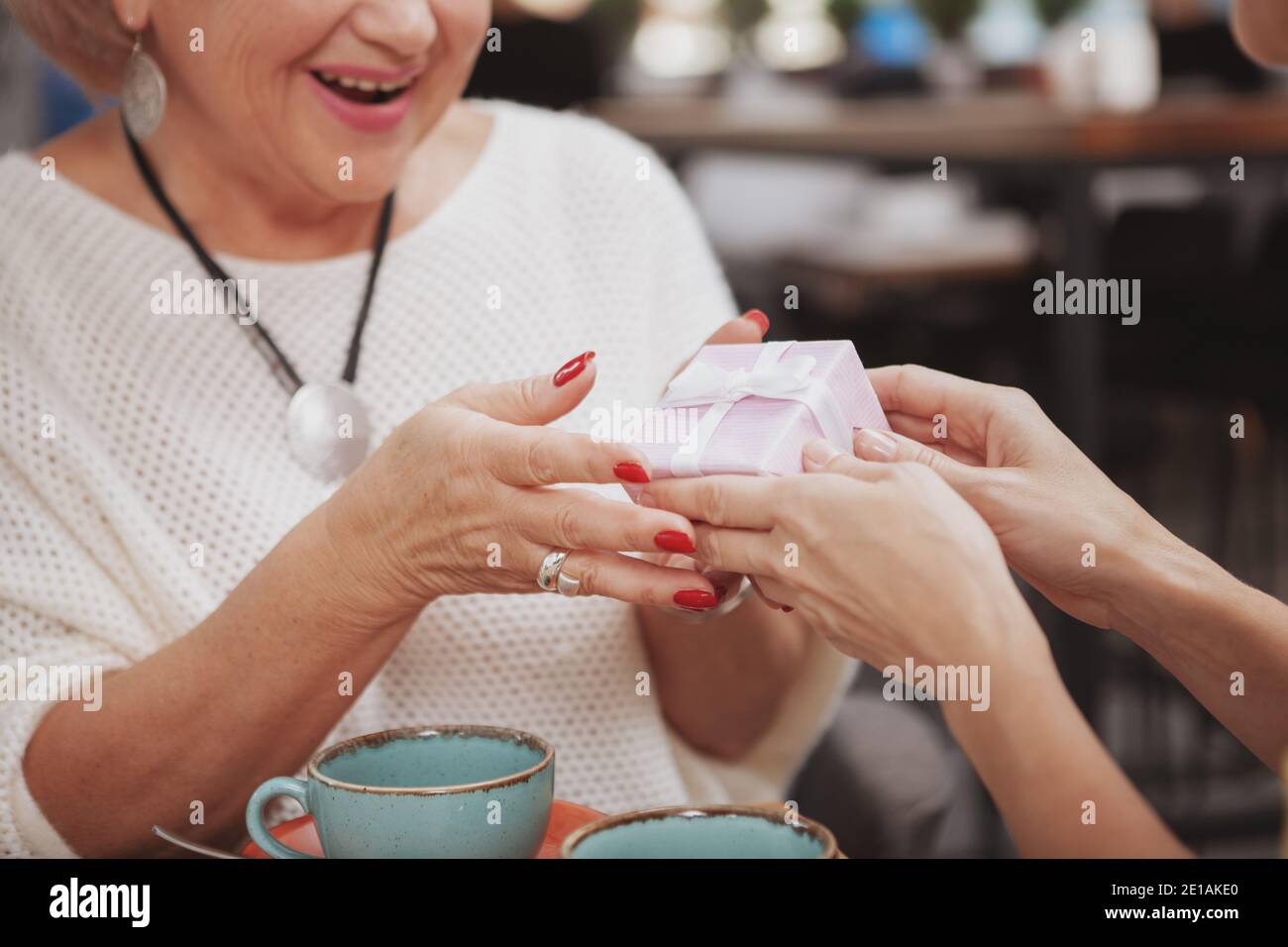 Premium Photo  Elderly woman receiving a gift from daughter