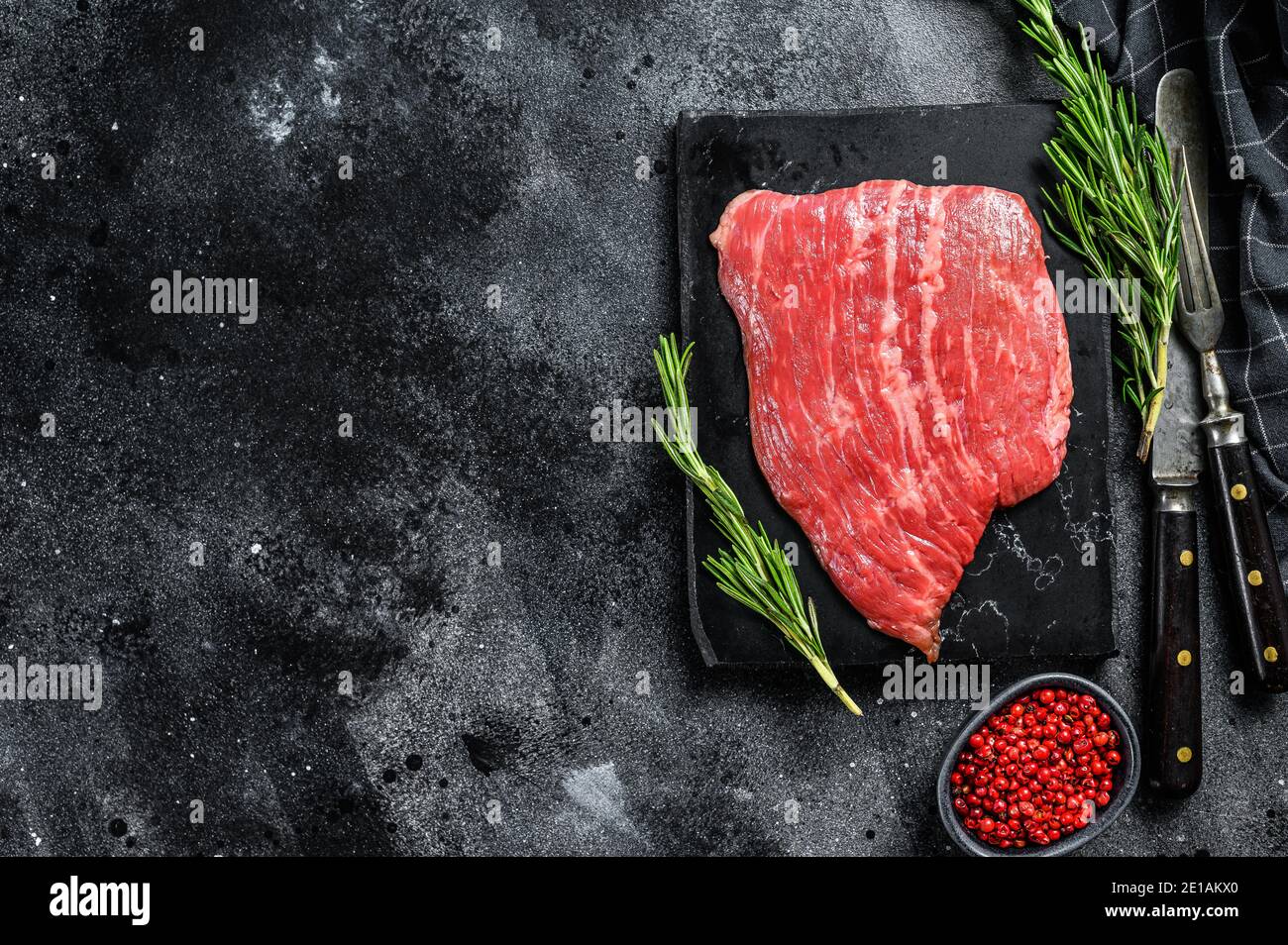 Flat iron steak. Raw Marble beef meat black Angus. Black background