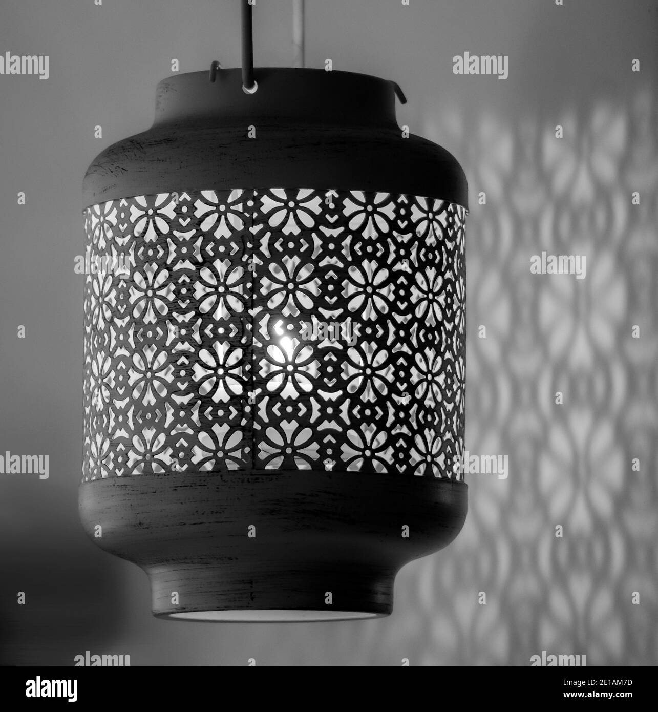 Candle light lamp with beautiful detailed antique patterns designs casting shadows over the near wall Stock Photo