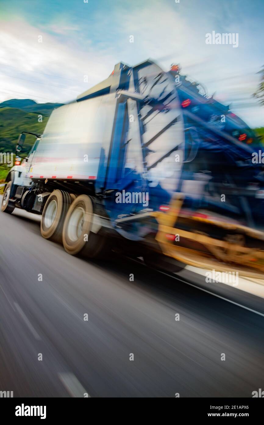 Pronounced angle view of a garbage truck traveling at high speed to deliver its trashy cargo Stock Photo