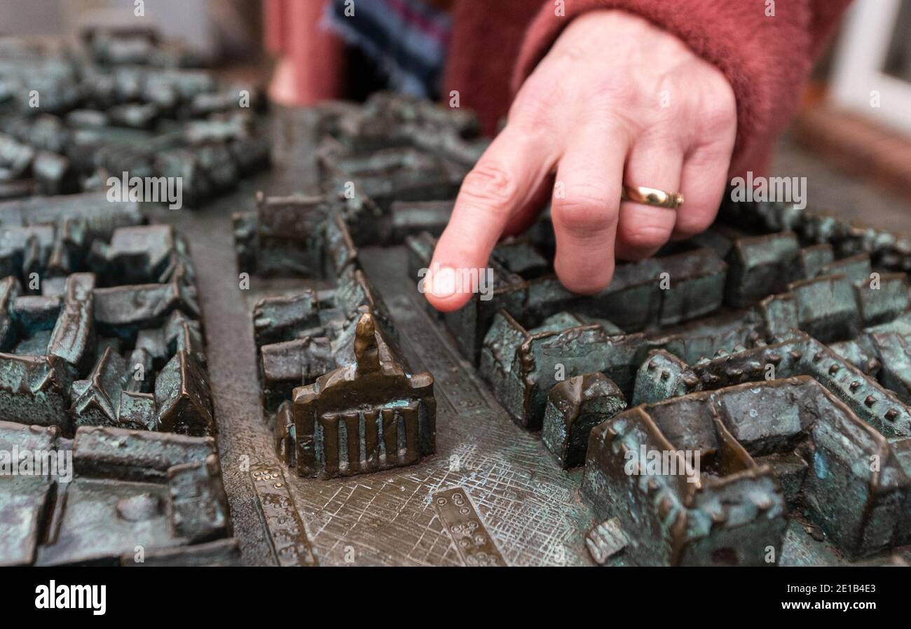10 December 2020, Lower Saxony, Lüneburg: Heike Düselder, Museum Director, points on a model, to the town hall of the city. The city of Lüneburg wants to apply for the Unesco World Heritage Site for the third time. Photo: Philipp Schulze/dpa Stock Photo