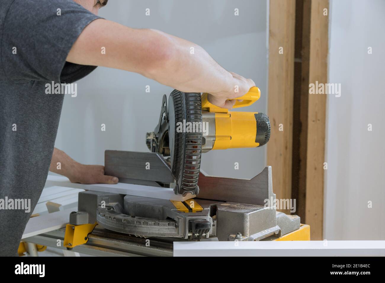Construction home cutting wooden trim molding on with circular saw