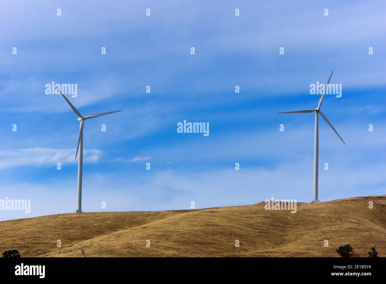 Wind turbine generators on a hillside generating power from wind energy. Wind farm located in