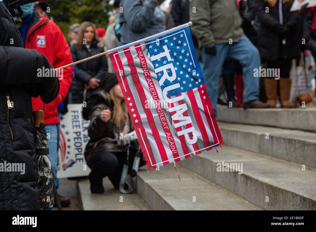 A protester holds Trump campaign flag during the demonstration.Supporters of President Donald Trump urged legislators to decertify the election during the 'Hear Us Roar' rally at the Pennsylvania State Capitol. Stock Photo