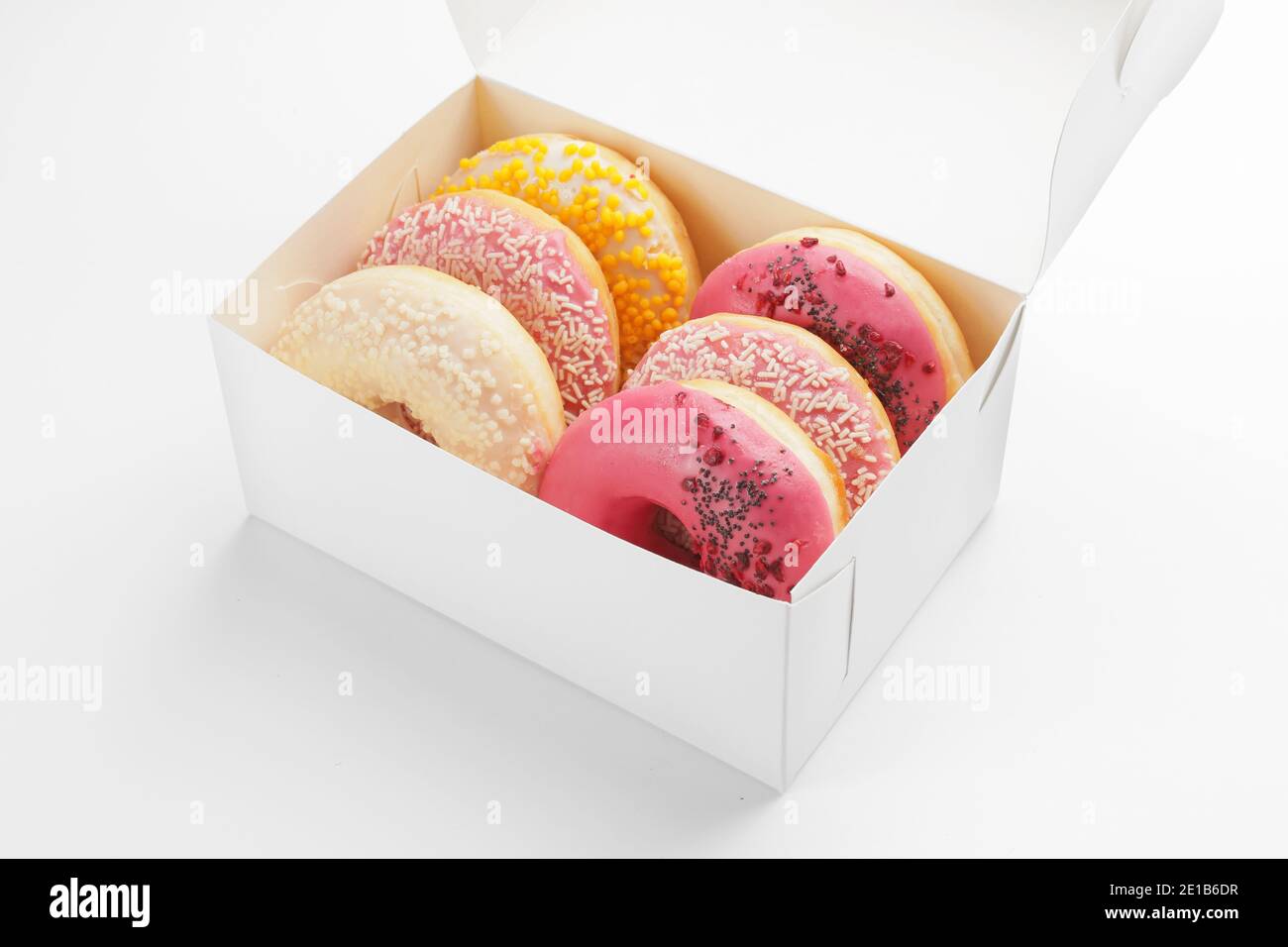 Sweet donuts in box on white background Stock Photo - Alamy