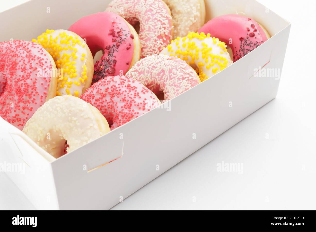 Sweet donuts in box on white background Stock Photo - Alamy
