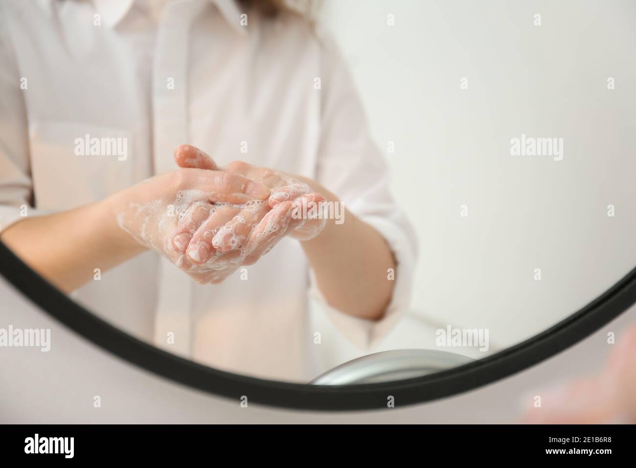 Young woman washing her hands in bathroom Stock Photo - Alamy