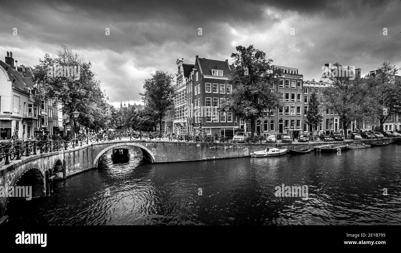 Canal boat entering the Keizersgracht canal from the Leliegracht canal in the old historic center of Amsterdam, the Netherlands Stock Photo