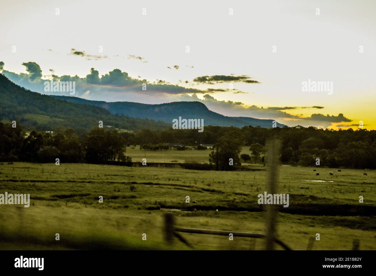 grazing and farmland near the Hunter Valley Australia at sunset with mountains and a beautiful sunset in the backdrop Stock Photo