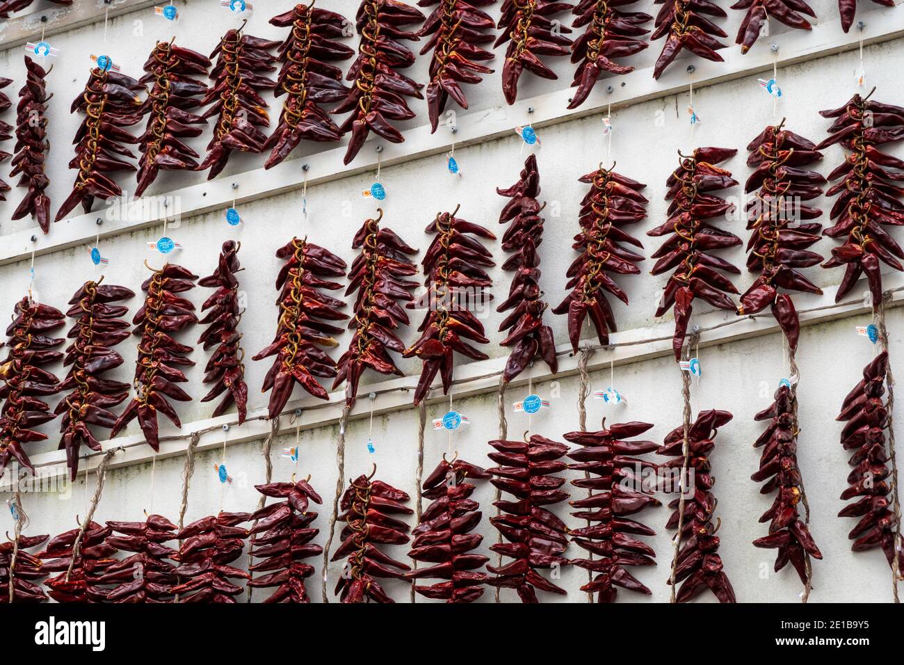 Strings of PDO Espelette chili peppers drying Stock Photo
