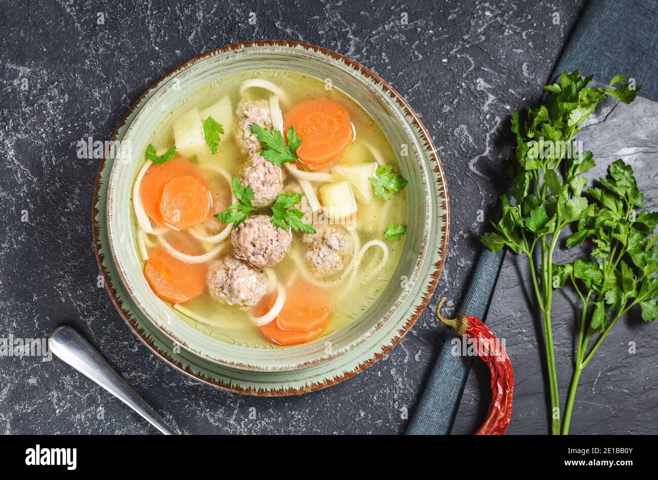 Meatball soup and ingredients on black stone table. Top view. Stock Photo