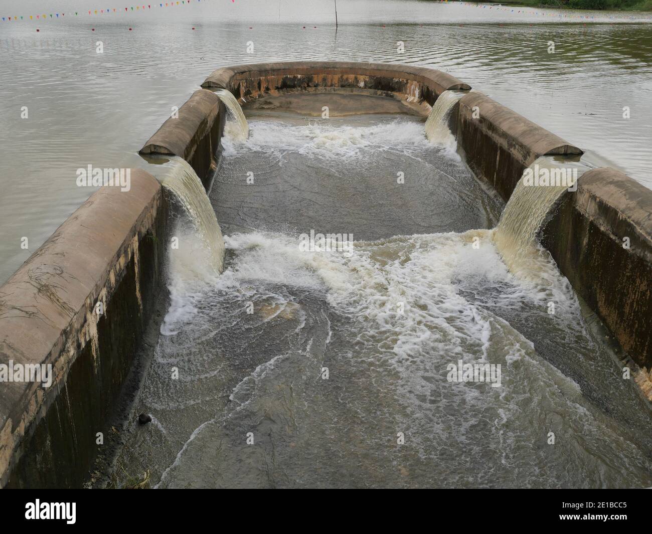 Turbid water in the dam overflows into the spillway, Irrigation during the rainy season, Thailand Stock Photo