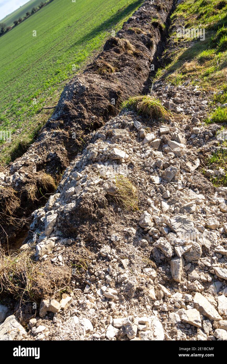 Rock fragments excavated from drainage ditch on farmland on chalk downs, Wiltshire, England, UK Stock Photo