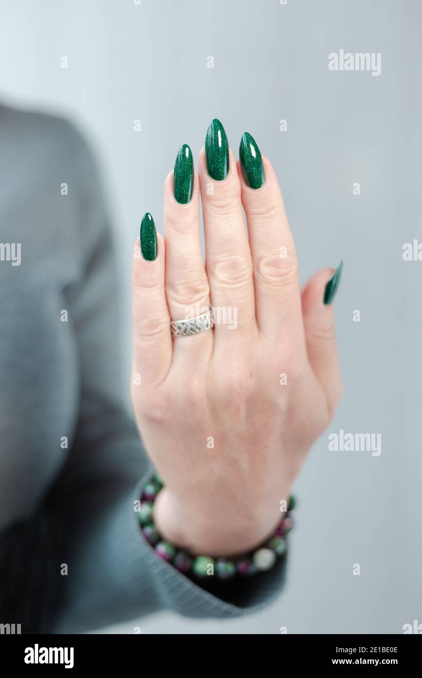 Female hands with long nails with green nail polish Stock Photo - Alamy