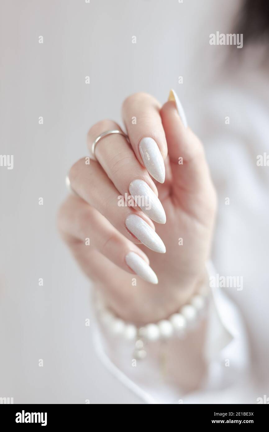 beautiful female hands with long nails light white manicure and a ...