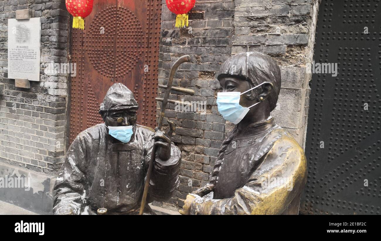 Bronzes statues located in local tourist attraction are seen wearing masks, Harbin city, northwest China¯s Heilongjiang province, 6 January 2021. *** Stock Photo