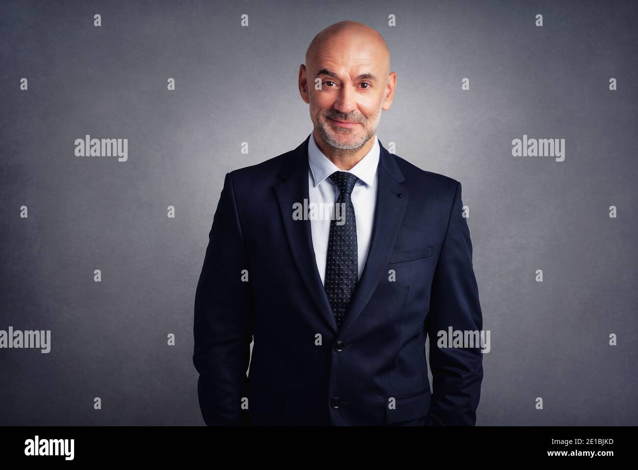 Studio portrait of confident businessman wearing suit while standing at ...