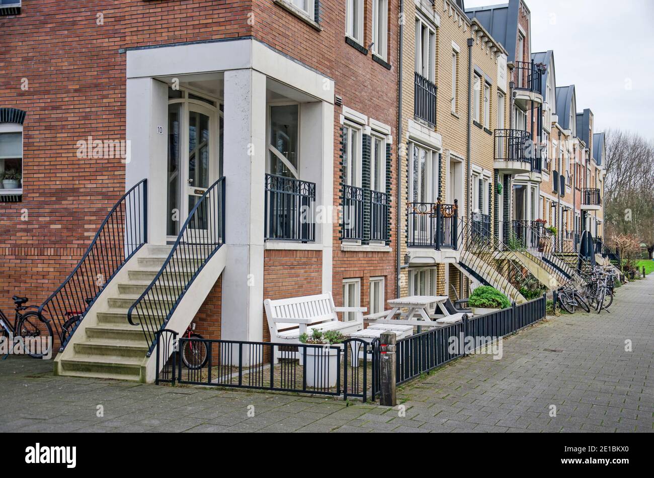 Voorschoten, The Netherlands, January 3, 2021: row of townhouses in Krimwijk neighbourhood with brick facades in a post-modern style with jugenstil in Stock Photo