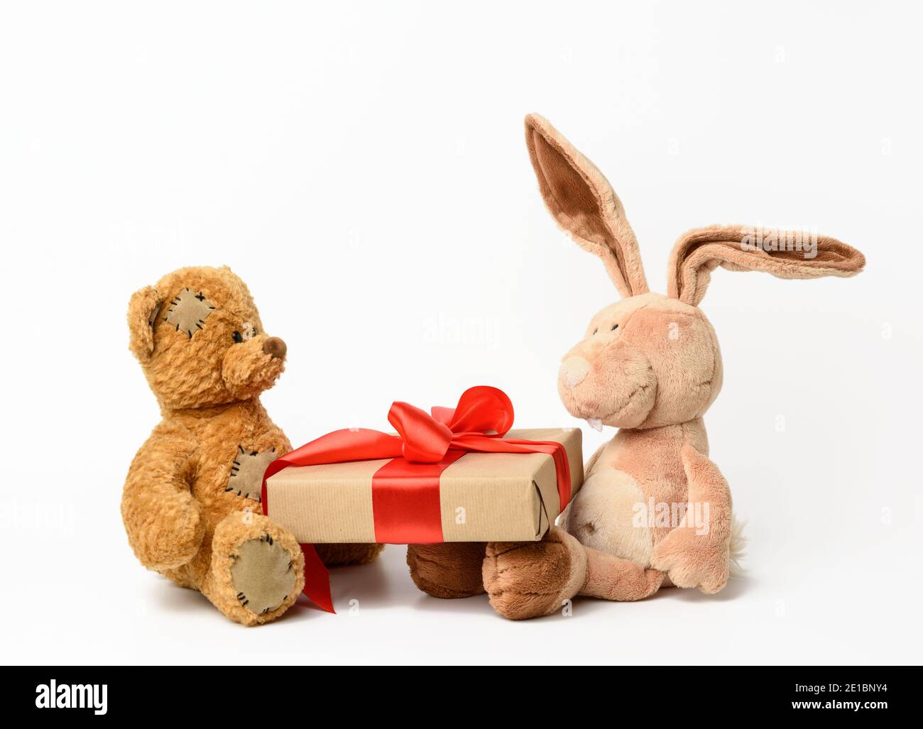 brown teddy bear and rabbit holding a box with a gift on a white ...