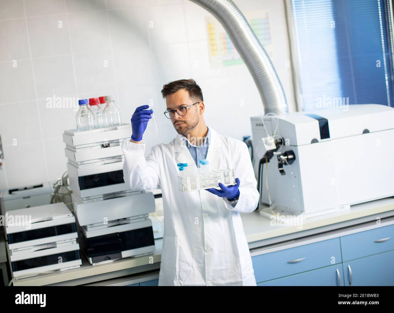Handsome young researcher workin with chemical samples in laboratory