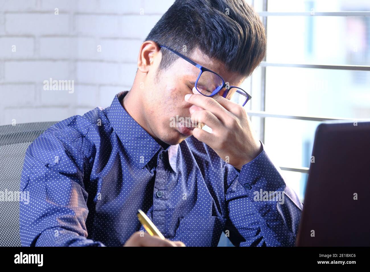 Close up of upset man suffering from strong eye pain while working on