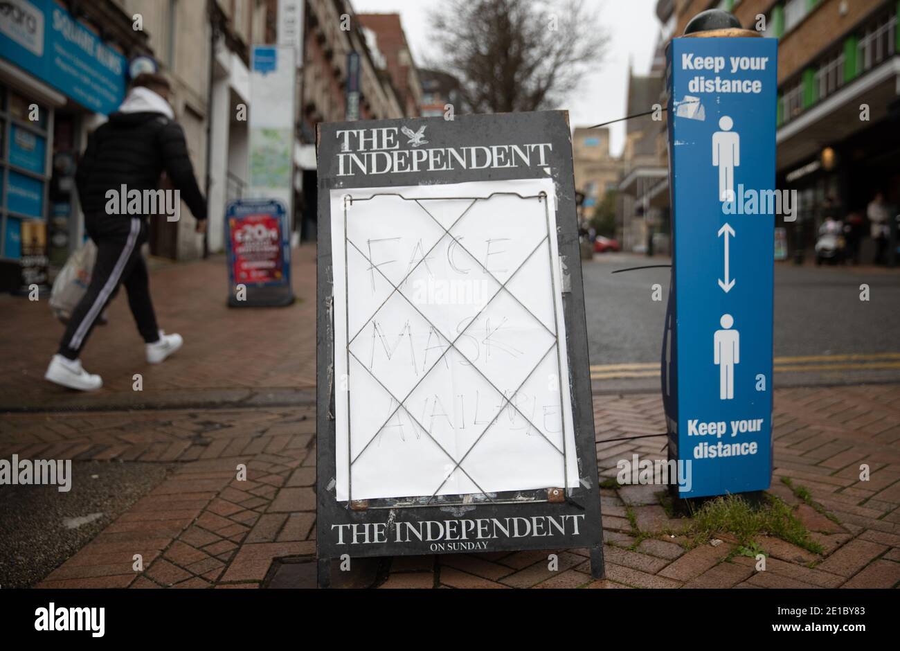A person walks past a newsagents' sign advertising face masks available in Bournemouth, Dorset. Prime Minister Boris Johnson ordered a new national lockdown for England which means people will only be able to leave their homes for limited reasons, with measures expected to stay in place until mid-February. Stock Photo