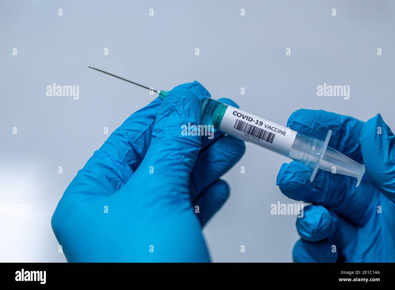 NIJMEGEN, NETHERLANDS - JANUARY 2: Corona vaccine / Covid-19 vaccine in a syringe being held by hands in blue surgical gloves. on January 2, 2021 in N Stock Photo