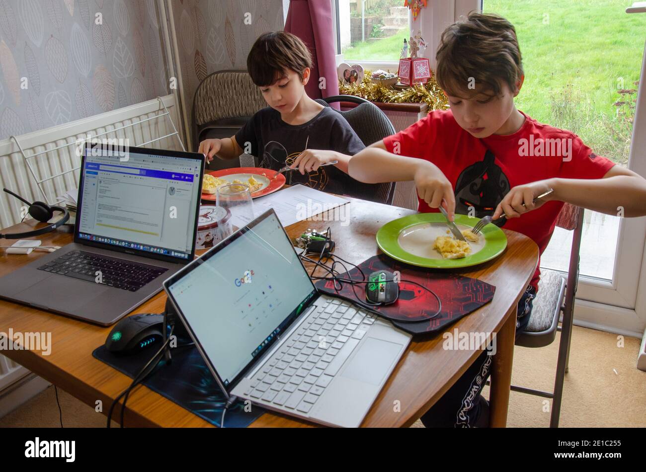 A dining room table in a UK home has to double as office desk, classroom and a place to eat due to home learning as a consequence of Covid lockdown Stock Photo