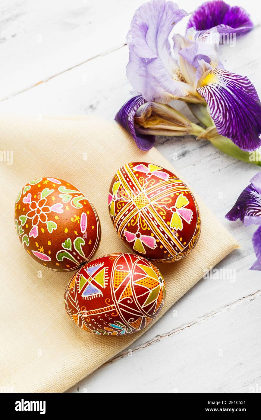 Three handmade Easter eggs decorated with wax-resist dyeing technique. Ukrainian pysanky on the table. Vertical composition Stock Photo