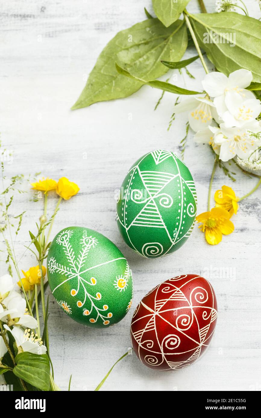Three pysanky handmade Easter eggs. Ukrainian pysanky decorated with wax-resist dyeing technique. Holiday postcard Stock Photo