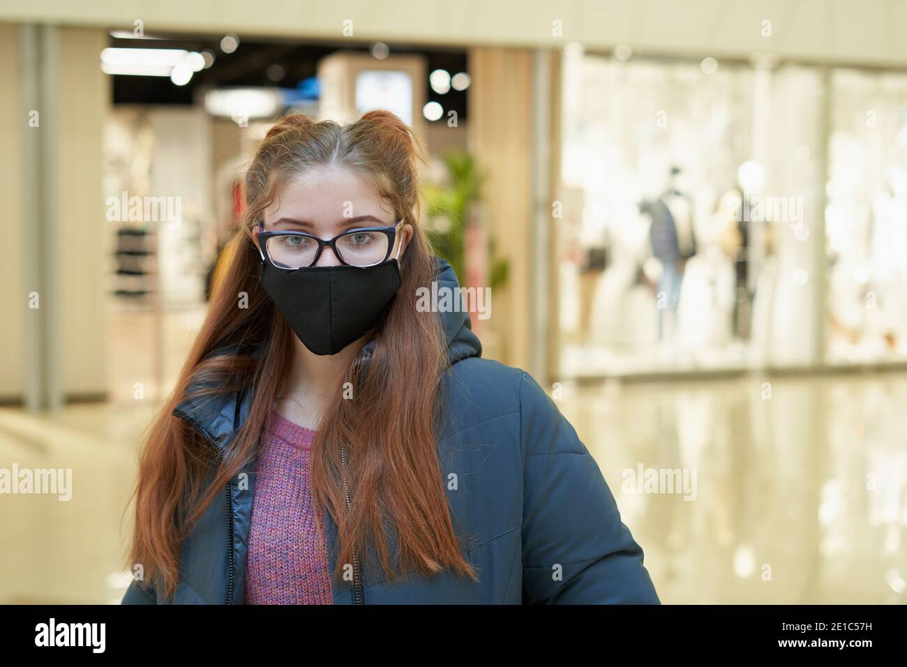 Portrait of a girl in a protective mask in a shopping mall Stock Photo