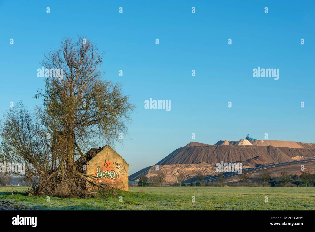 Wolmirstedt, Germany. 19th Dec, 2020. A ruined house stands in a field next to a high stand. Behind it, the tailings pile of the Zielitz potash plant can be seen. The K S company will expand the tailings pile by 200 hectares over the next few years. Permission for this has now been granted by the State Office for Geology and Mining (LAGB). This will secure the production of fertilizers and salt in Zielitz until 2054. The tailings pile is also called Kilimanjaro. Credit: Stephan Schulz/dpa-Zentralbild/ZB/dpa/Alamy Live News Stock Photo