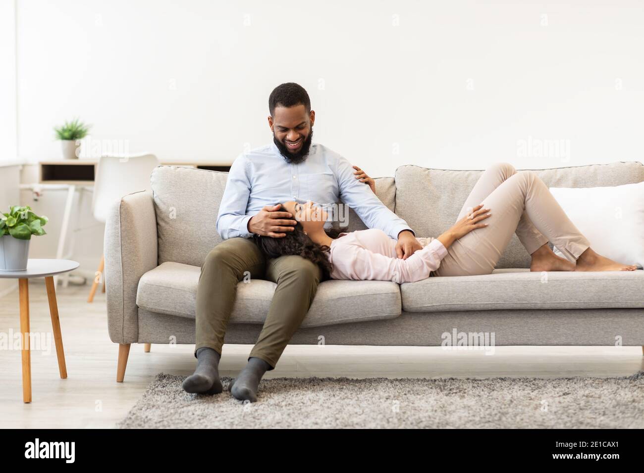 African american couple spending weekend together lying on couch Stock ...