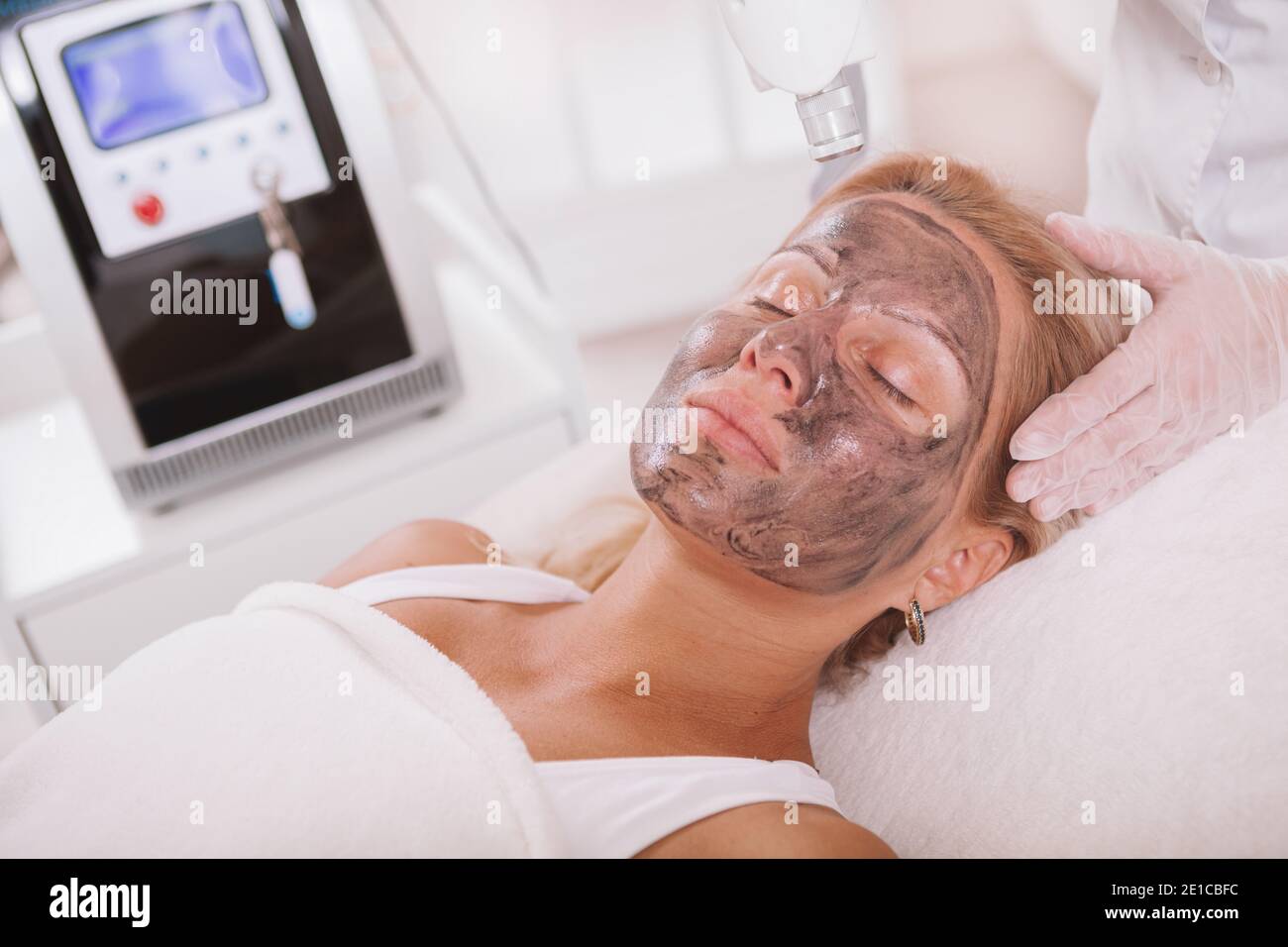 Beautiful mature woman getting carbon laser peel treatment at beauty salon.  Cosmetologist doing anti age skincare laser treatment on the face of a fem  Stock Photo - Alamy