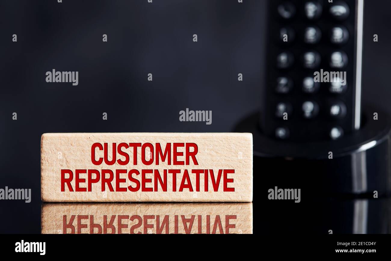 The word customer representative on wooden block with telephone background. Business concept for customer guidance, support or technical help. Stock Photo