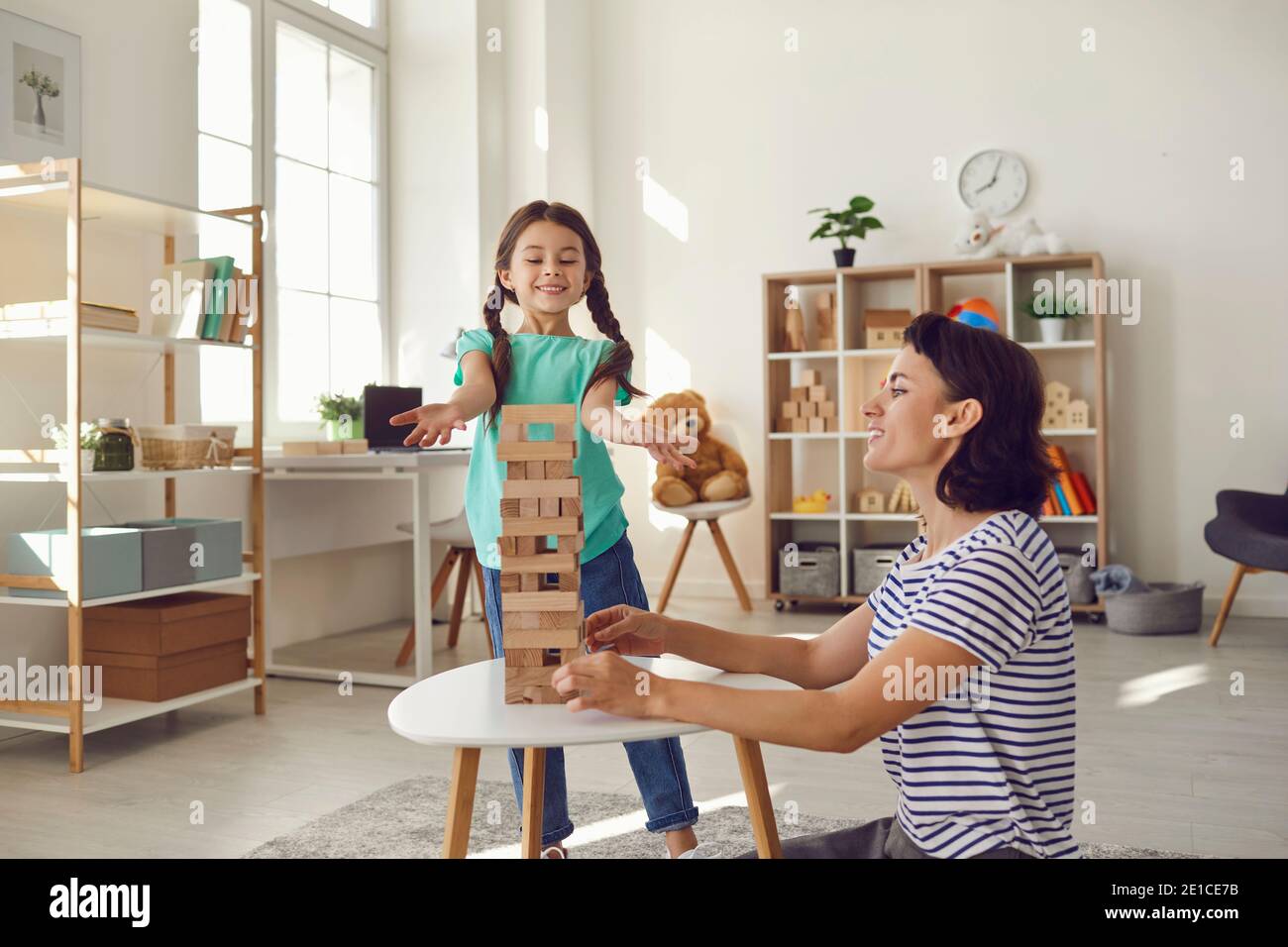 Mother and daughter play board games in the living room. Education and