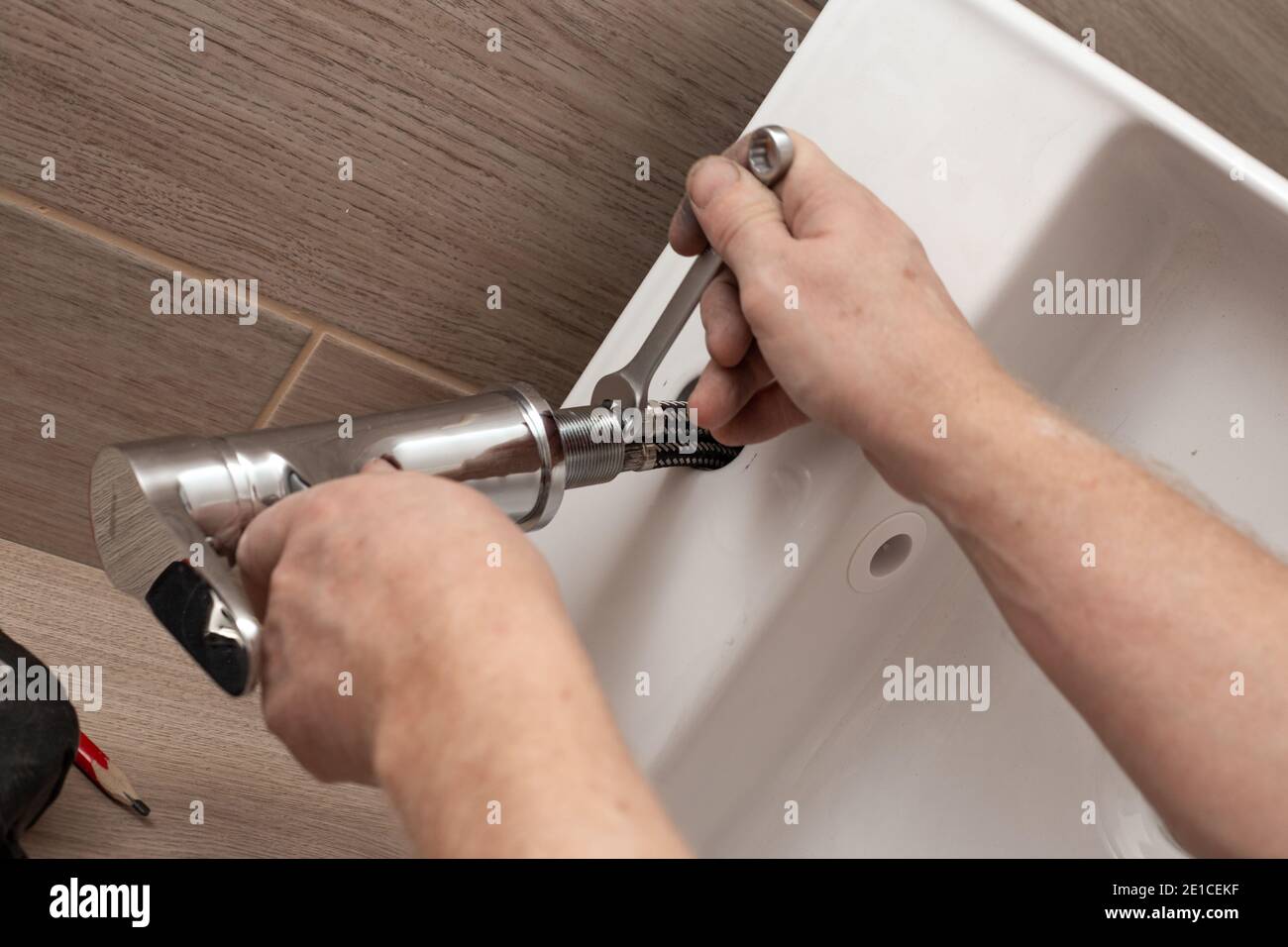 Installing a bathroom sink on a wooden countertop. Mixer installation