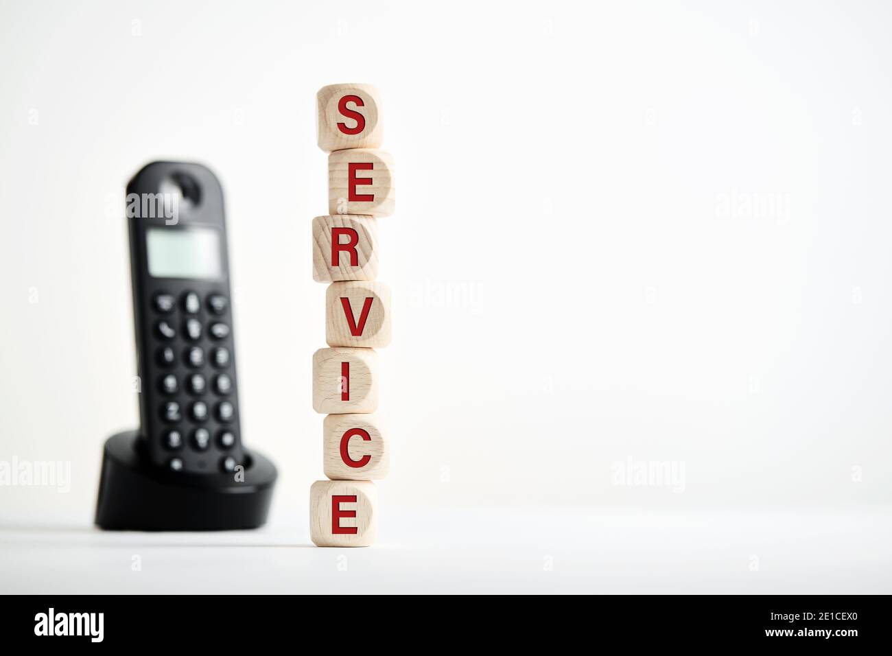 The word service on wooden block with telephone background. Business concept for asking guidance, support or technical help. Stock Photo