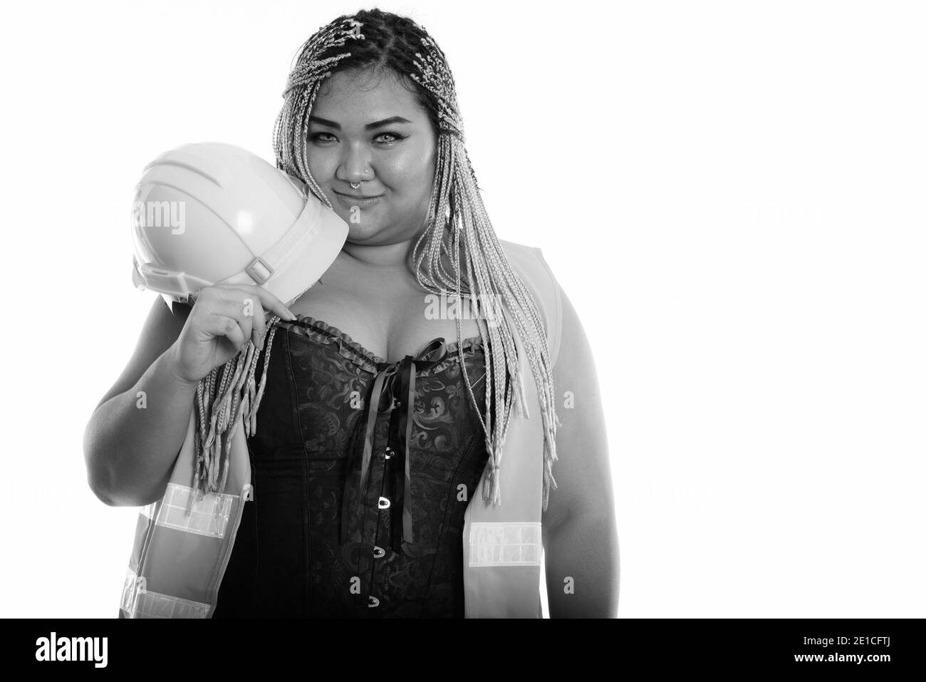 Young fat Asian construction woman holding safety helmet near the face Stock Photo
